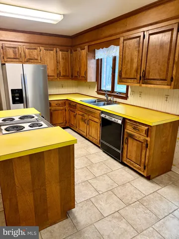 a kitchen with granite countertop a stove top oven a sink and a refrigerator