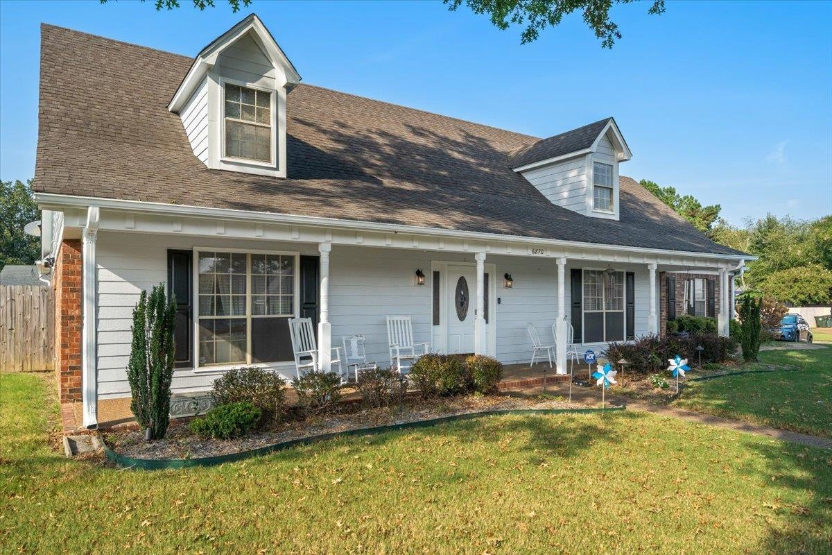 Cape cod-style house featuring covered porch and roof with shingles