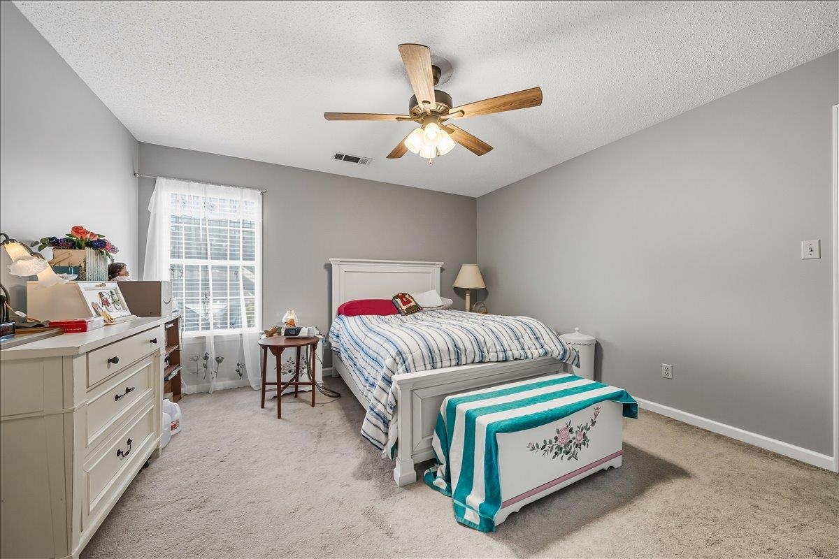6870 Deerfield Road Bartlett, TN 38135 - Photo 19 of 28 Bedroom with a textured ceiling, a ceiling fan, and light carpet