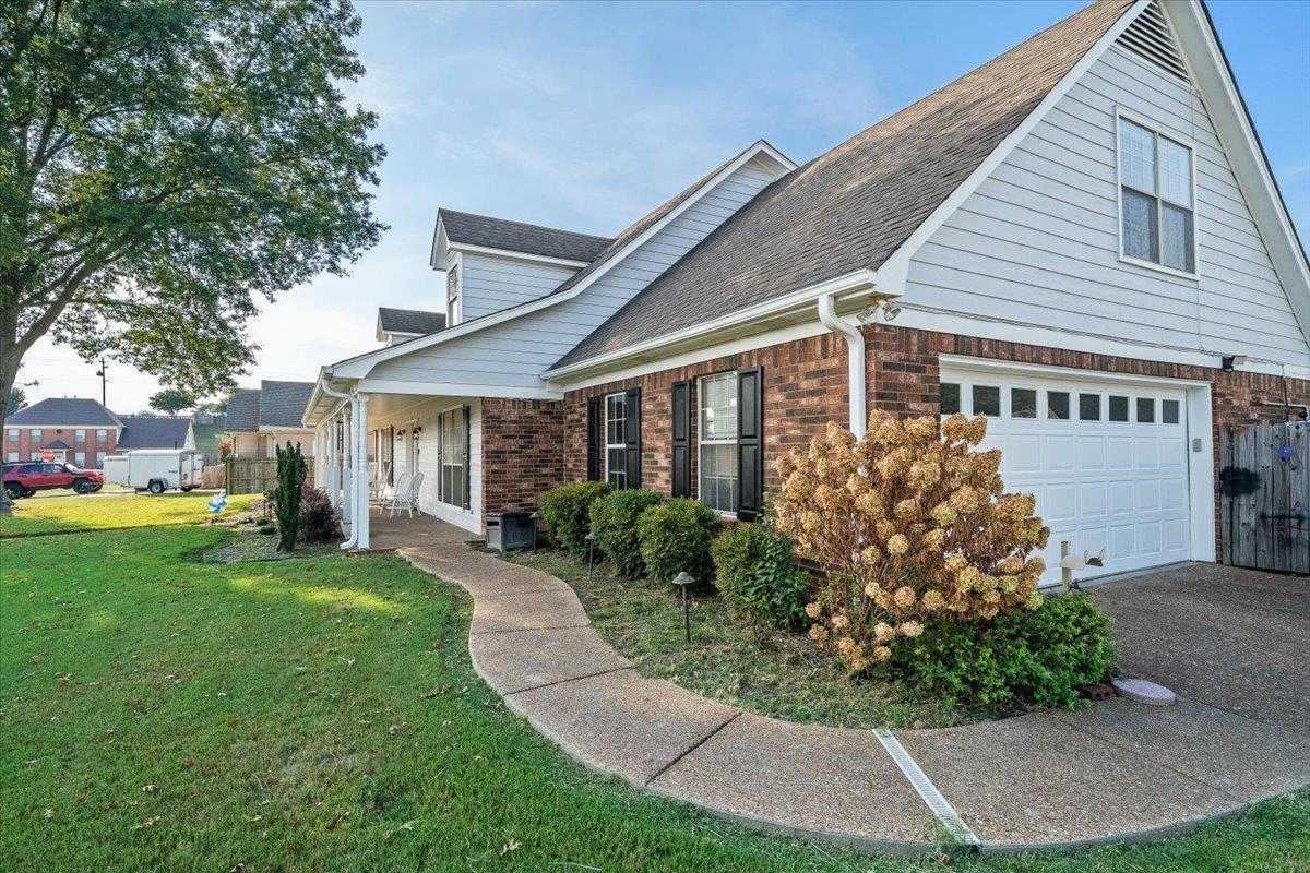 6870 Deerfield Road Bartlett, TN 38135 - Photo 2 of 28 View of side of home with brick siding, roof with shingles, driveway, and covered porch