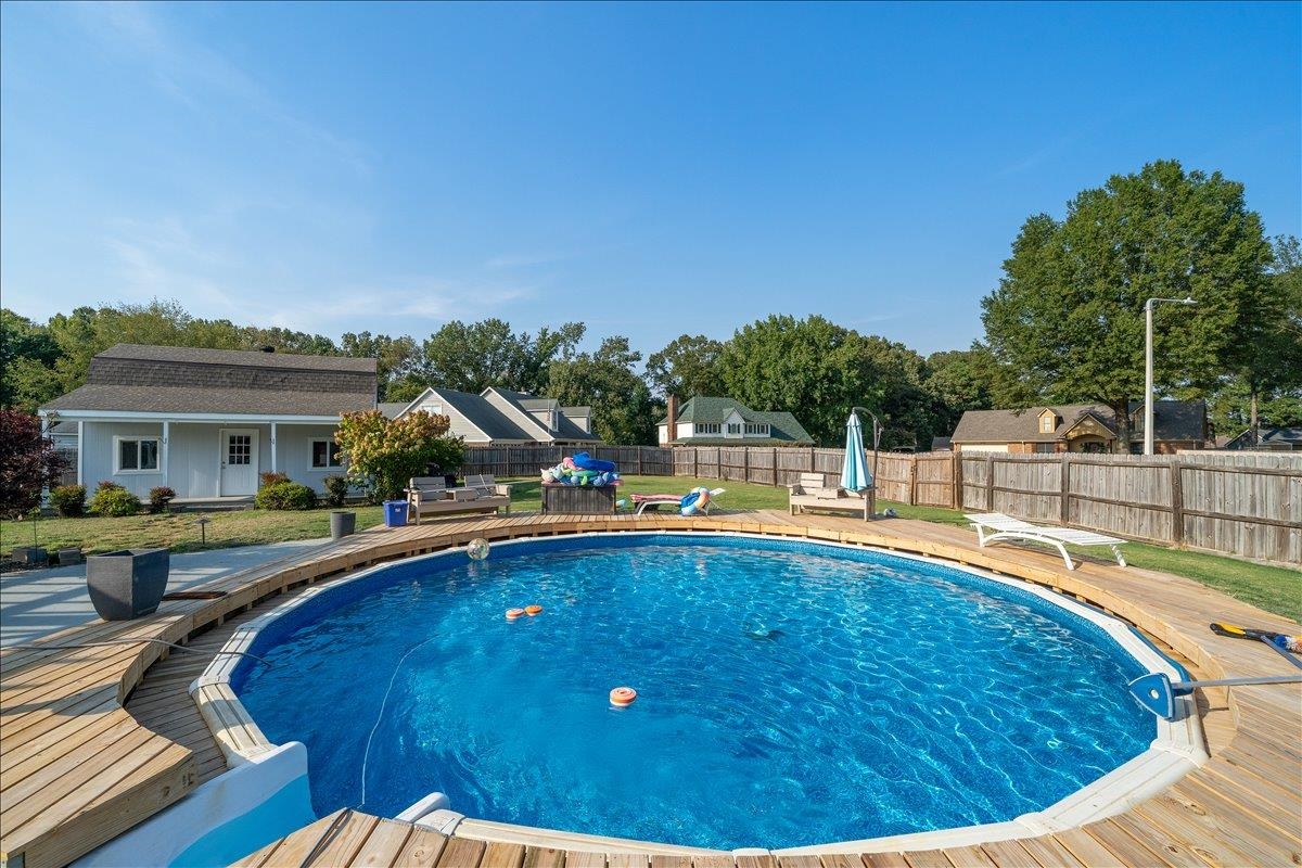 6870 Deerfield Road Bartlett, TN 38135 - Photo 24 of 28 View of pool featuring a fenced backyard, an outbuilding, patio surround, and a wooden deck
