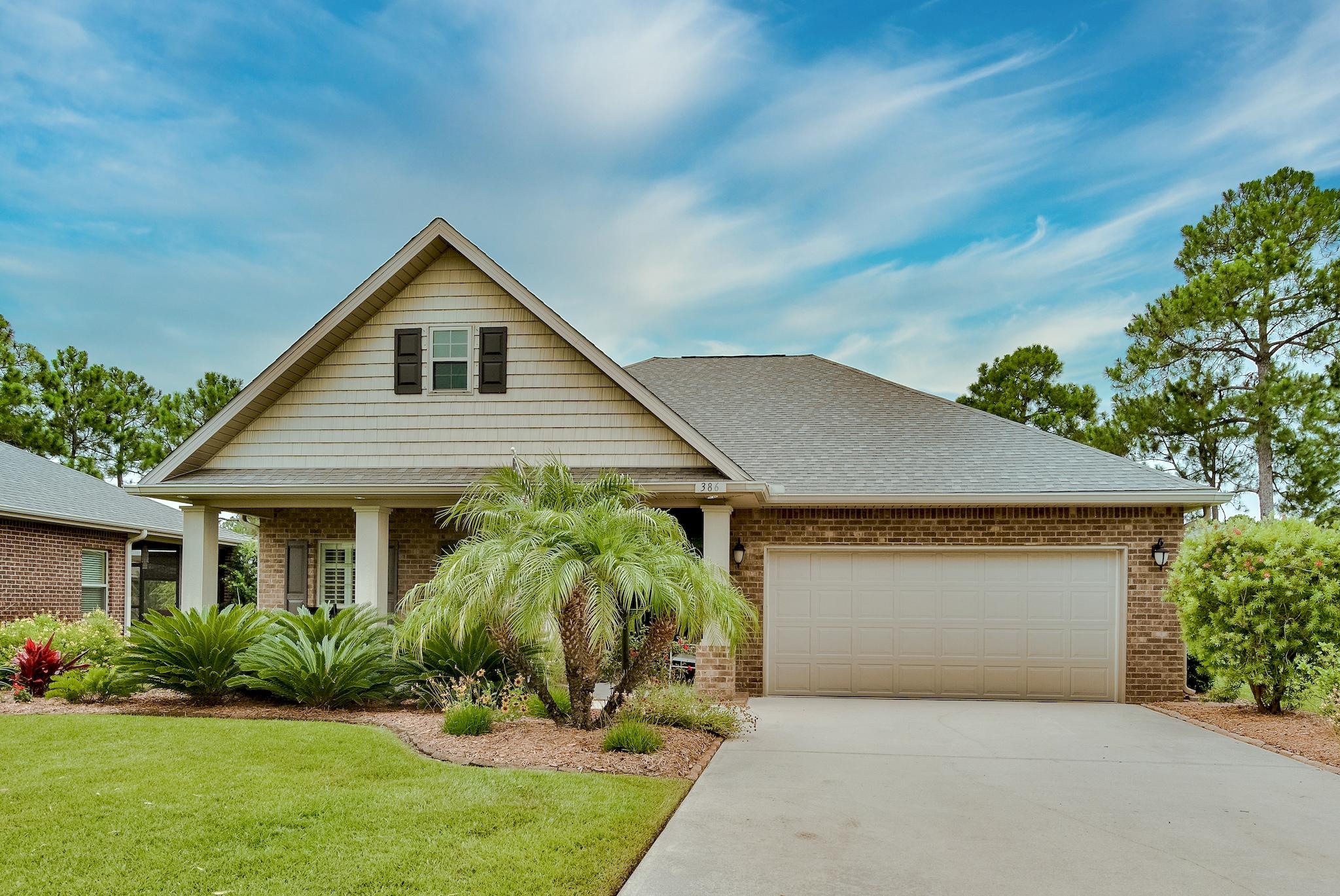 386 Pin Oak Loop Santa Rosa Beach, FL 32459 - Photo 1 of 47 a front view of a house with garden