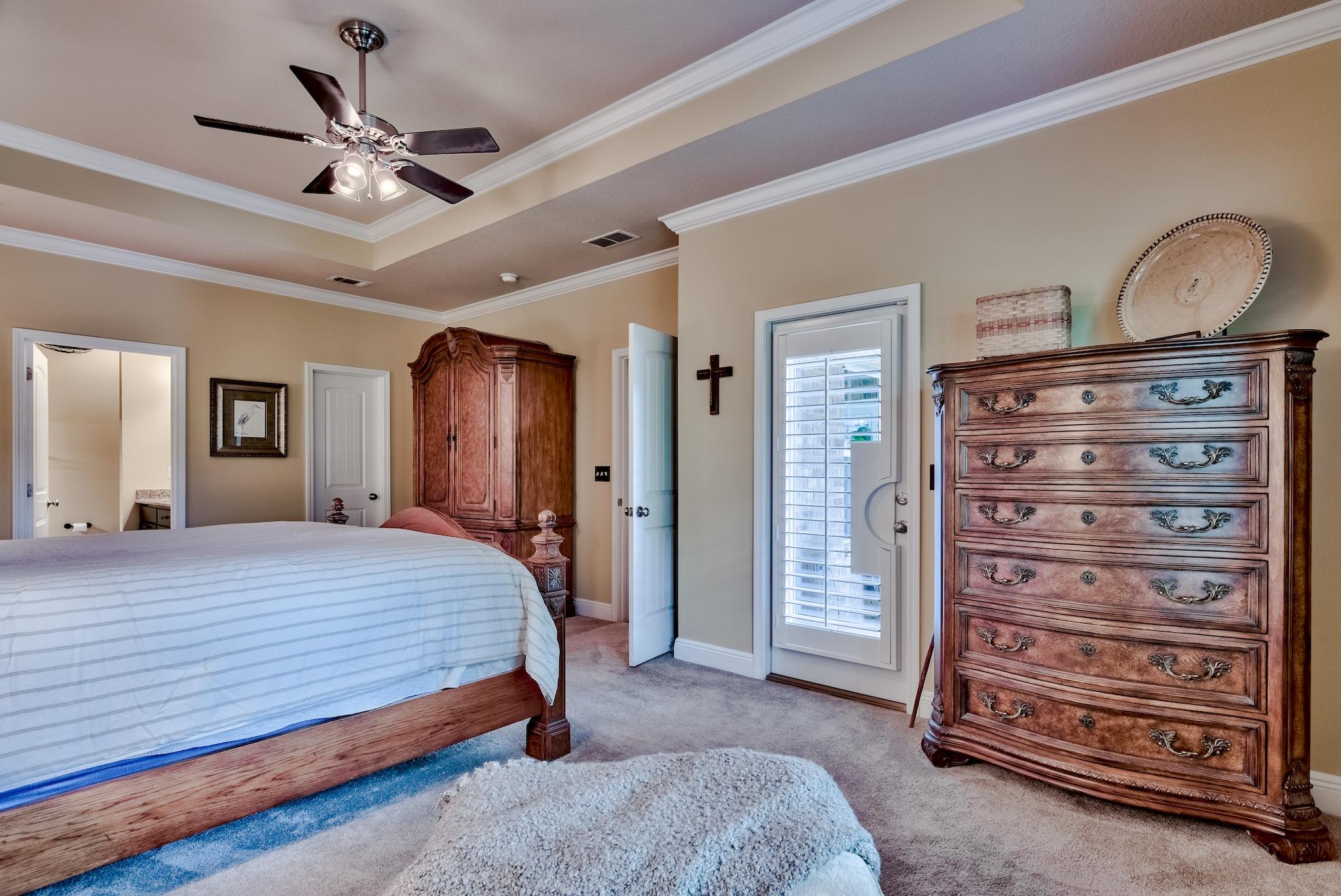 386 Pin Oak Loop Santa Rosa Beach, FL 32459 - Photo 20 of 47 a bedroom with a bed a dresser and a chandelier