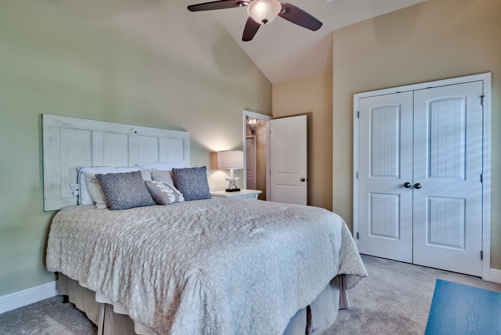 386 Pin Oak Loop Santa Rosa Beach, FL 32459 - Photo 23 of 47 a bedroom with a bed and a chandelier