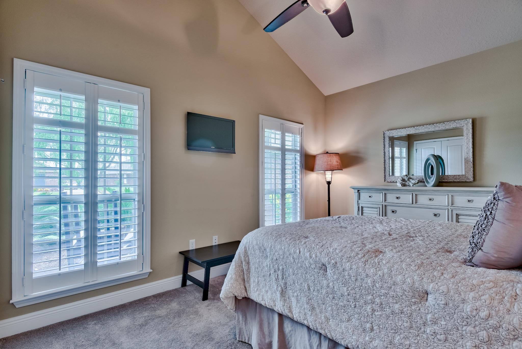386 Pin Oak Loop Santa Rosa Beach, FL 32459 - Photo 24 of 47 a bedroom with a large bed and a chandelier