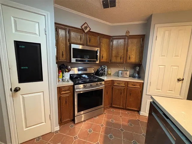 a kitchen with granite countertop a stove top oven microwave and refrigerator