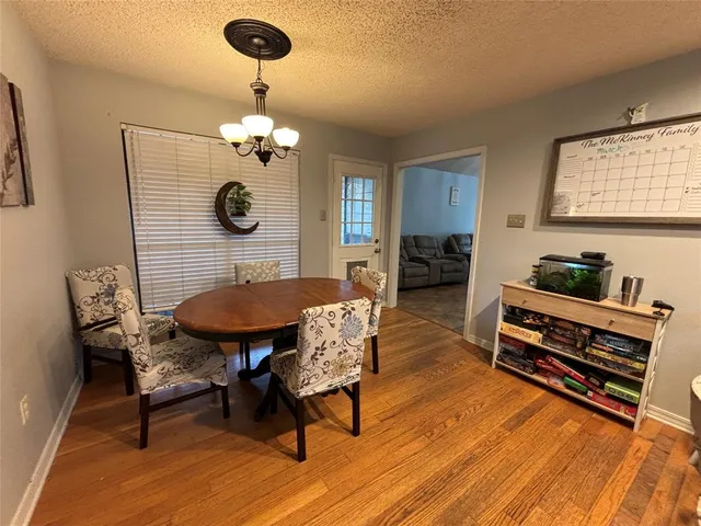 a living room with furniture a dining table and paintings on the wall