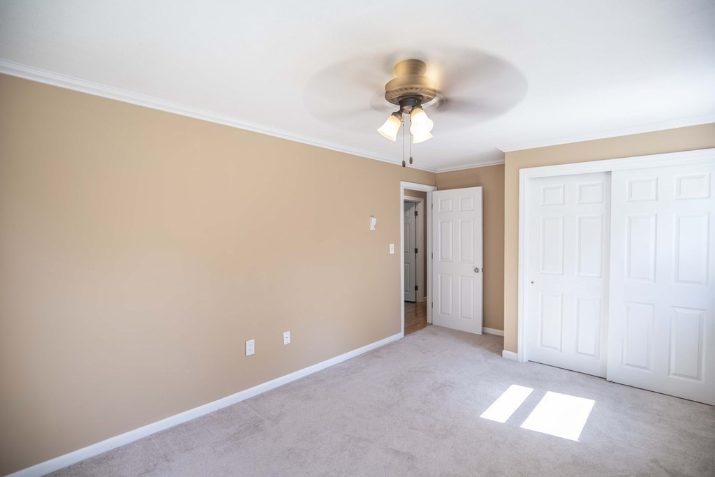 182 Ayer Road Shirley, MA 01464 - Photo 13 of 35 an empty room with a chandelier fan and windows