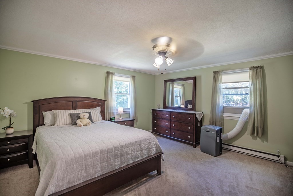 182 Ayer Road Shirley, MA 01464 - Photo 14 of 35 a bedroom with a bed and a chandelier next to a window