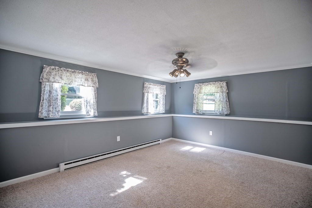 182 Ayer Road Shirley, MA 01464 - Photo 18 of 35 an empty room with windows and chandelier fan