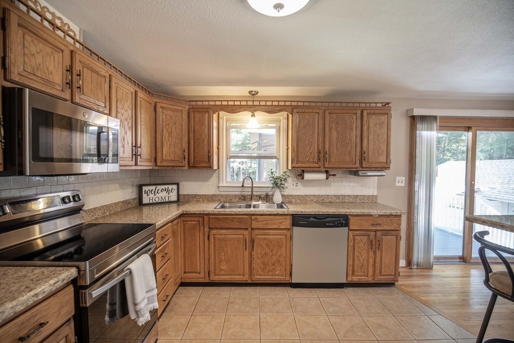 182 Ayer Road Shirley, MA 01464 - Photo 2 of 35 a kitchen with stainless steel appliances granite countertop a stove a sink and a microwave