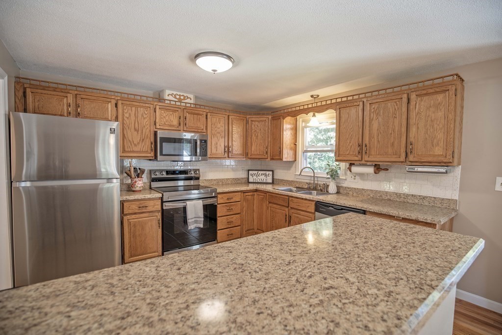 182 Ayer Road Shirley, MA 01464 - Photo 3 of 35 a kitchen with granite countertop a refrigerator stove top oven and sink