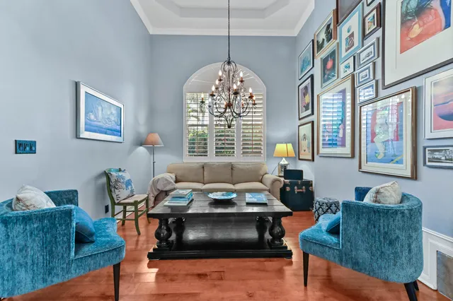 a kitchen with stainless steel appliances kitchen island granite countertop a refrigerator a stove a sink and white cabinets with wooden floor