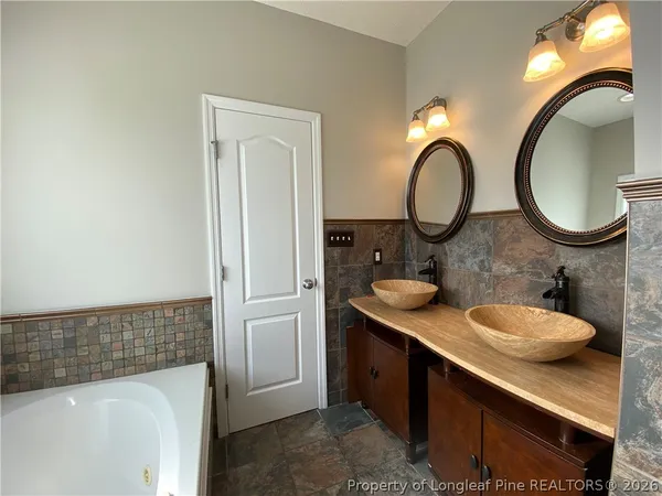 a bathroom with a tub shower and a sink