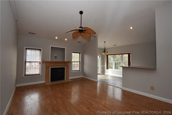 an empty room with windows and fan