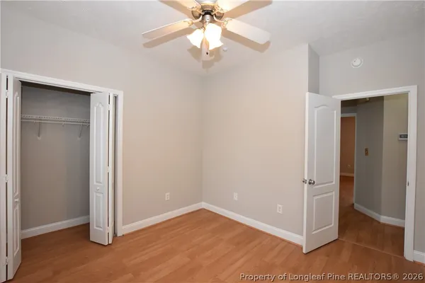 an empty room with a window and a fan