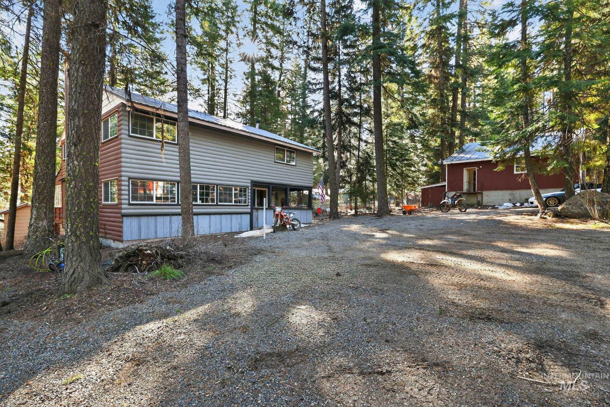 654 Bings Road Cascade, ID 83611 - Photo 3 of 45 View of property exterior with faux log siding and gravel driveway