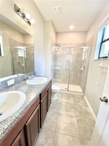 a bathroom with a granite countertop sink a mirror and shower