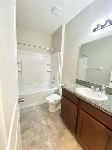 a bathroom with a granite countertop sink toilet a mirror and shower