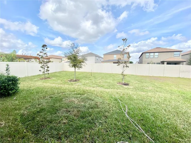 a view of yard with swimming pool and trees in the background