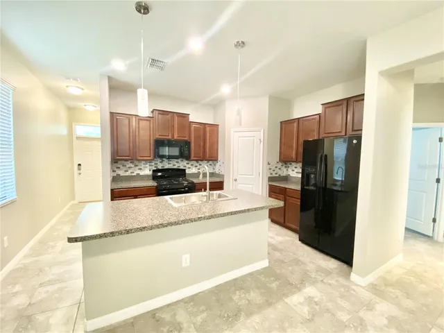 a large kitchen with a center island and stainless steel appliances