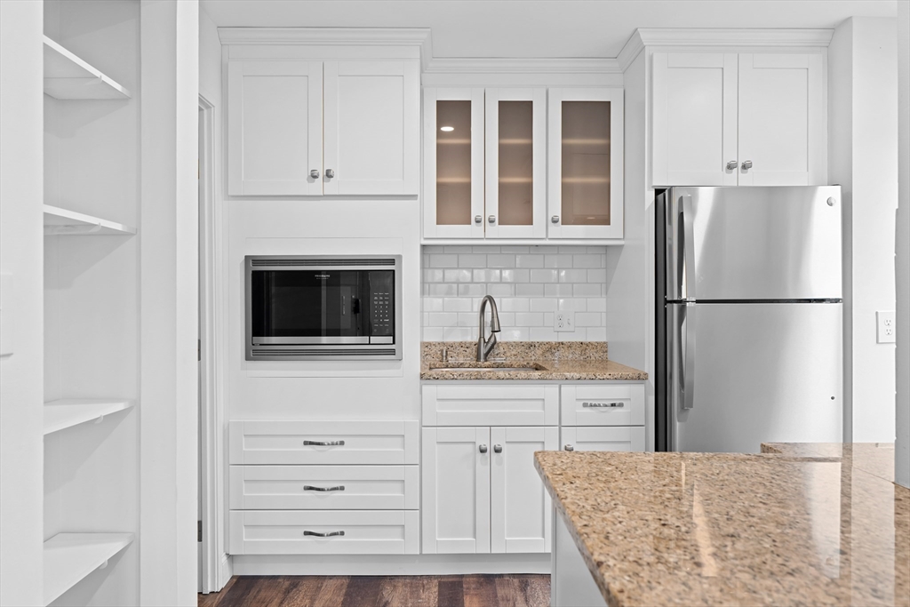 a kitchen with granite countertop cabinets and refrigerator