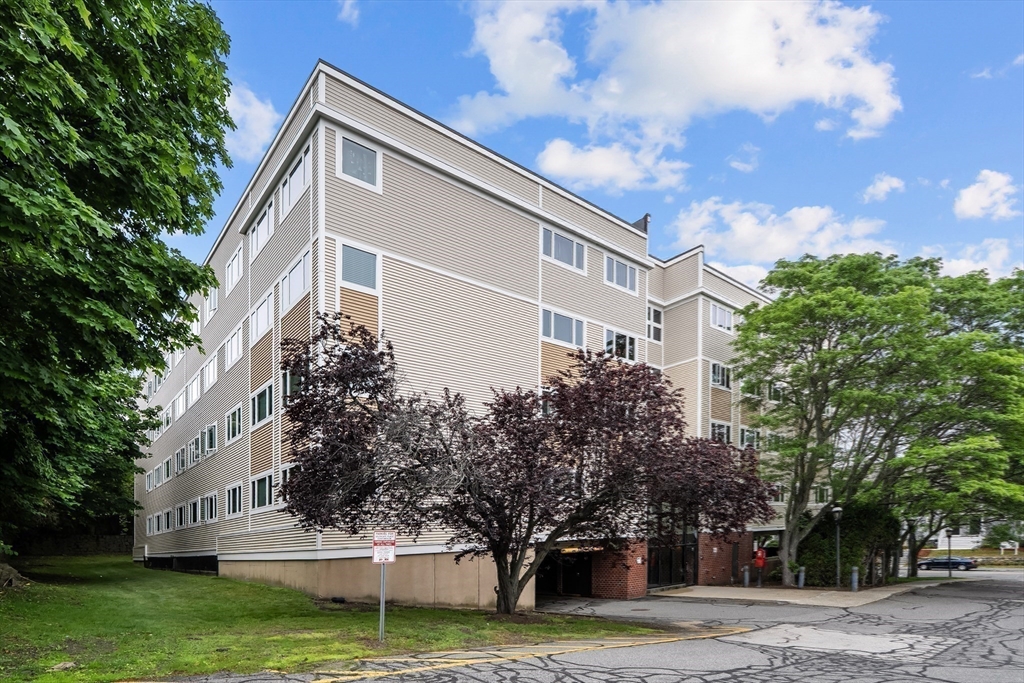 35 Des Moines Road, Unit 310 Quincy, MA 02169 - Photo 21 of 22 a tall white building with trees in front of it