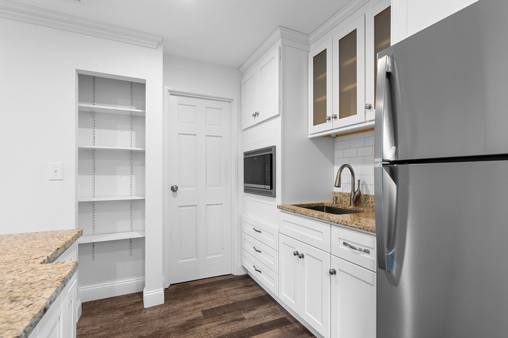 35 Des Moines Road, Unit 310 Quincy, MA 02169 - Photo 5 of 22 a kitchen with granite countertop cabinets stainless steel appliances and a wooden floor