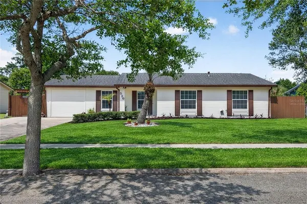 a front view of a house with a potted plant and floor to ceiling window