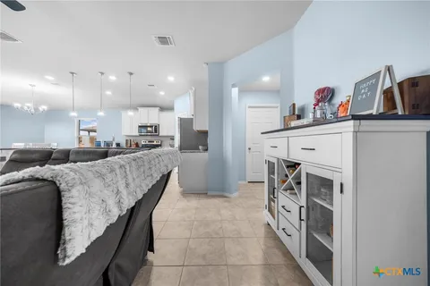 a kitchen with stainless steel appliances kitchen island granite countertop a sink counter space cabinets and a refrigerator