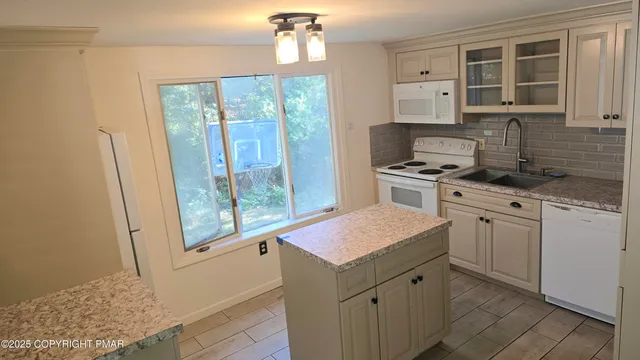 a kitchen with a stove a sink and a window