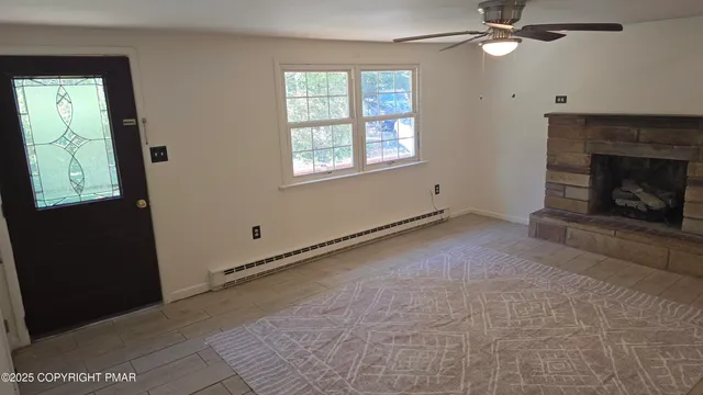 an empty room with windows and fan