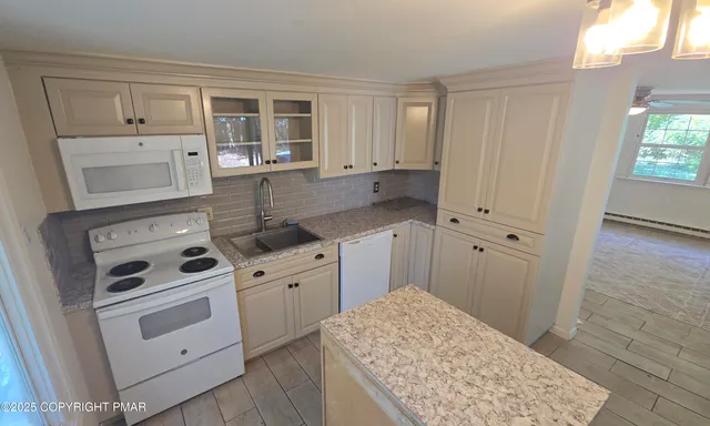 a kitchen with white cabinets and white appliances