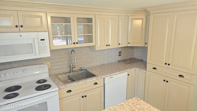 a kitchen with white cabinets and sink