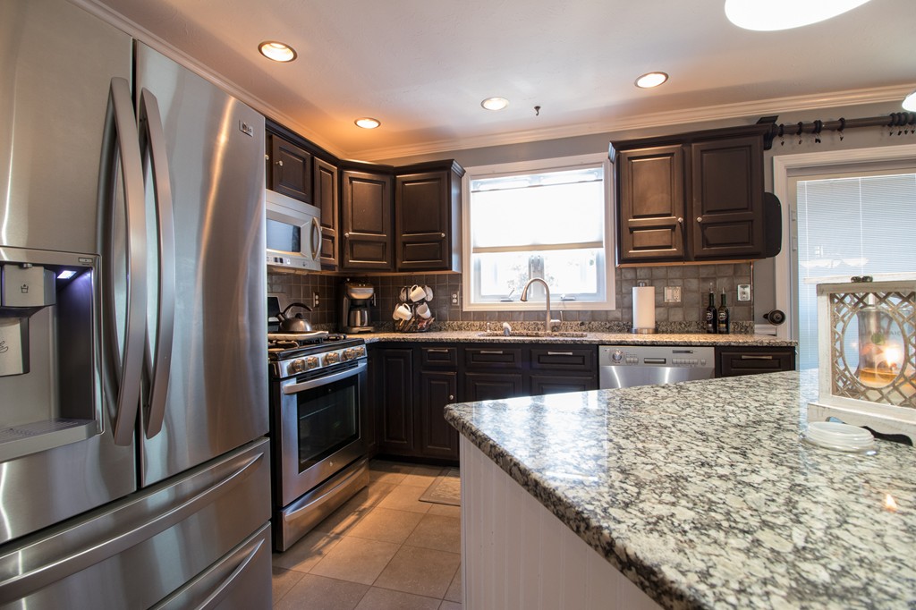 152 Carter Street Fall River, MA 02721 - Photo 5 of 30 a kitchen with kitchen island granite countertop a refrigerator and a sink