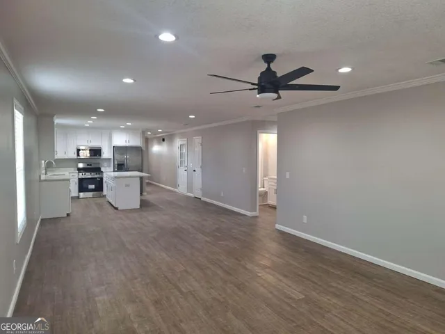 a view of an empty room with a kitchen