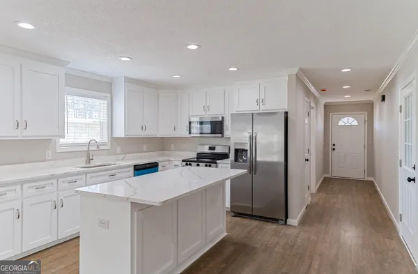 a view of a kitchen and a sink cabinets and wooden floor