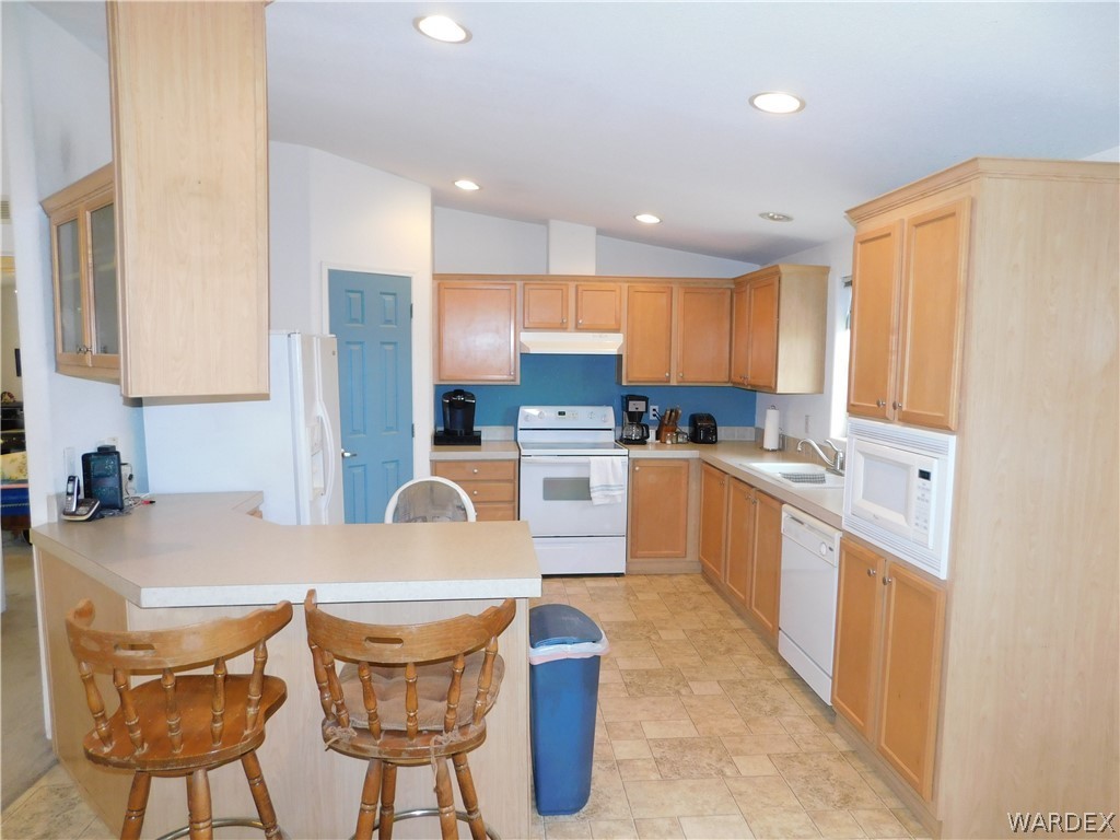 4810 Eloy Road Golden Valley, AZ 86413 - Photo 18 of 35 a kitchen with stainless steel appliances granite countertop a table chairs and a refrigerator