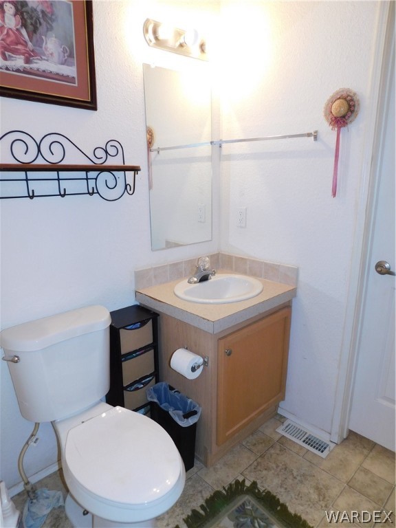 4810 Eloy Road Golden Valley, AZ 86413 - Photo 25 of 35 a bathroom with a toilet a sink and mirror