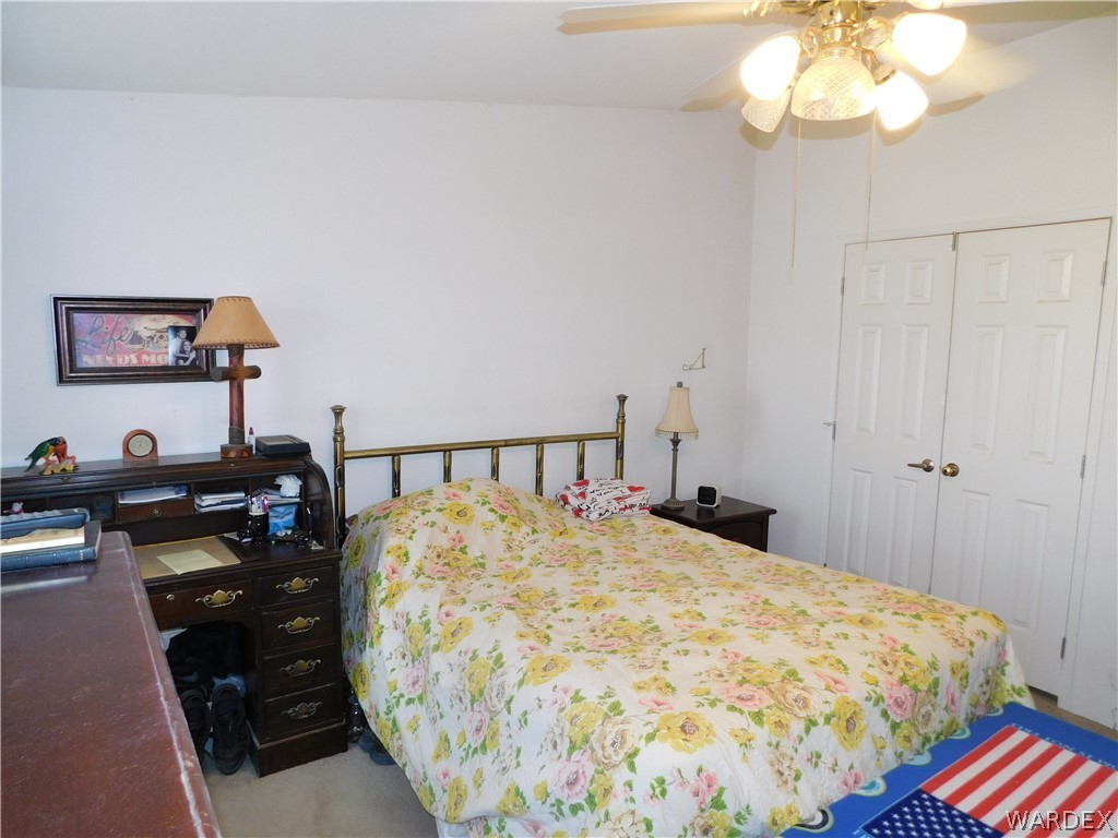 4810 Eloy Road Golden Valley, AZ 86413 - Photo 30 of 35 a bedroom with a bed and a chandelier