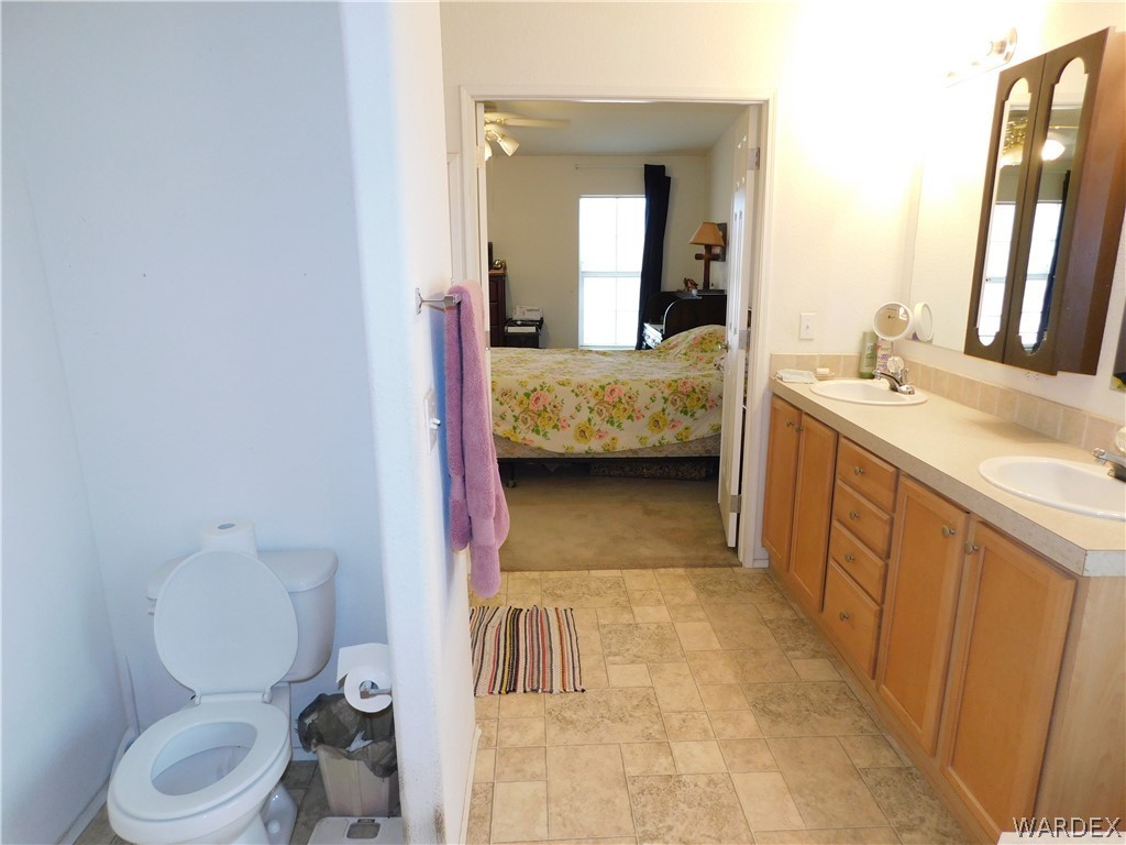 4810 Eloy Road Golden Valley, AZ 86413 - Photo 35 of 35 a en suite bathroom with a sink a toilet and a mirror