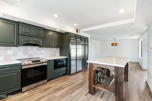 a kitchen with granite countertop a stove top oven and cabinets