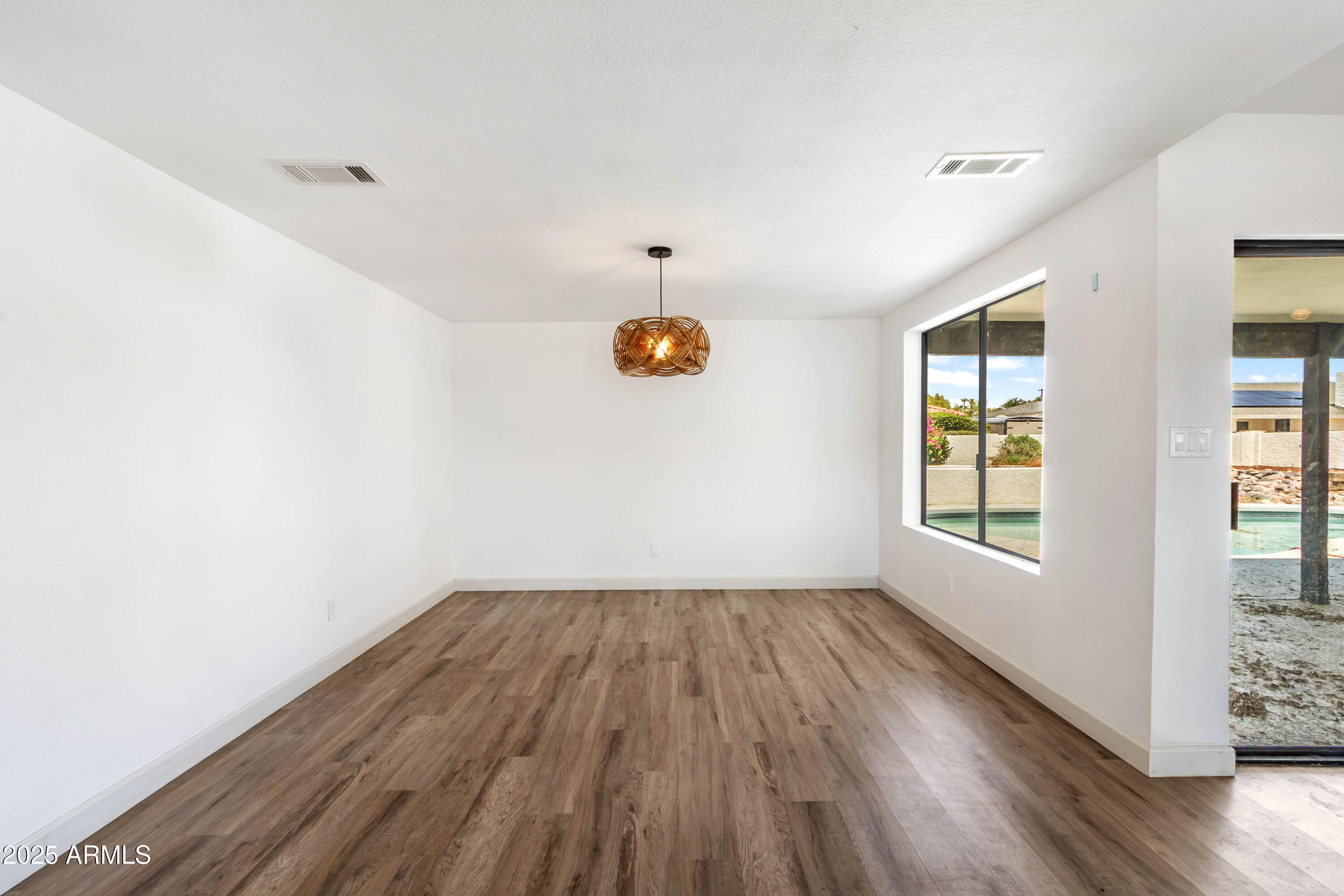 2228 East Jaeger Street Mesa, AZ 85213 - Photo 12 of 35 a view of an empty room with wooden floor and a window