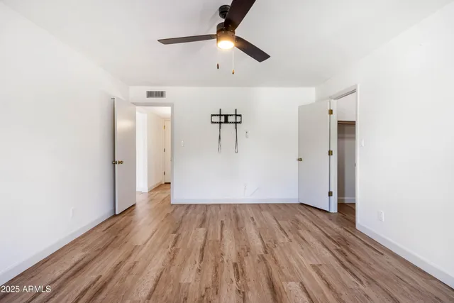 a view of empty room with wooden floor