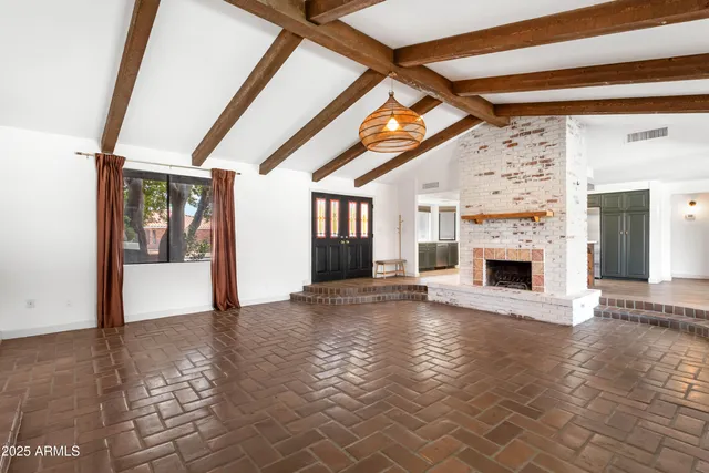 a view of empty room with fireplace and wooden floor