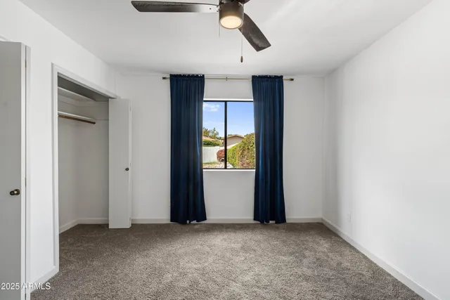 an empty room with closet and windows