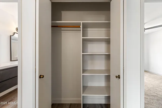 a view of walk in closet with empty racks