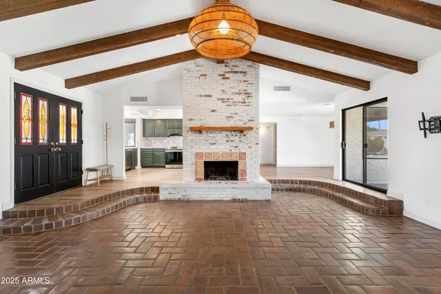 a living room with a fireplace furniture a ceiling fan and a rug