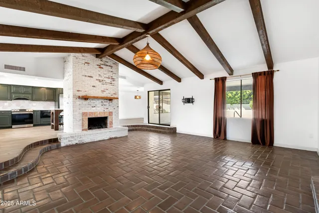 a view of empty room with fireplace and window