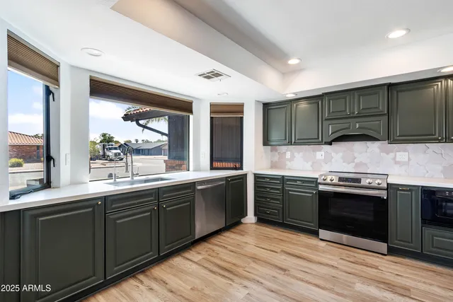 a kitchen with stainless steel appliances granite countertop wooden cabinets sink and stove